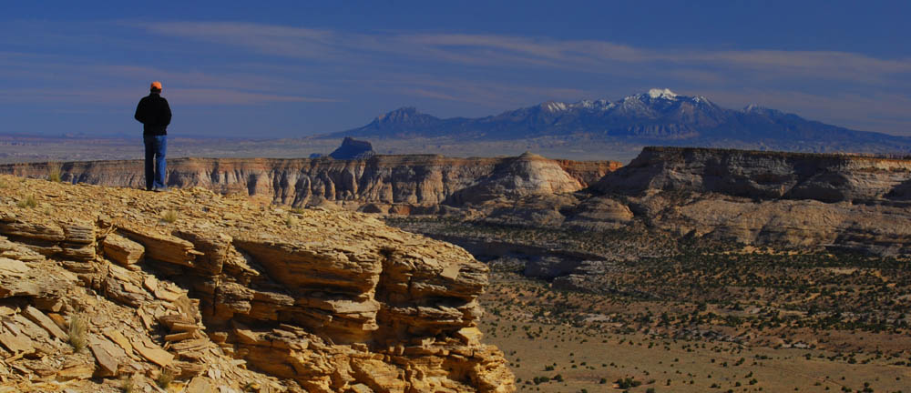 Hiker overlooking Segers Hole and the Henry Mountains. Copyright Ray Bloxham/SUWA.
