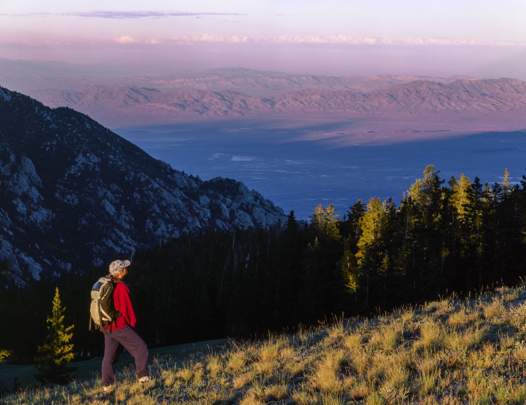 Utah. USA. Hiker at sunset near the crest of the Deep Creek Mountains above Granite Creek drainage. Great Salt Lake Desert in distance. Proposed Deep Creek Mountains BLM Wilderness. Great Basin.
